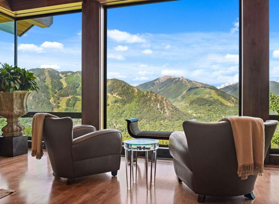 Experience breathtaking mountain vistas from this luxurious living space, featuring floor-to-ceiling windows that frame a stunning panoramic view.