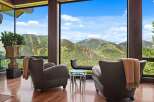 Experience breathtaking mountain vistas from this luxurious living space, featuring floor-to-ceiling windows that frame a stunning panoramic view.