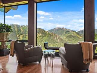 Experience breathtaking mountain vistas from this luxurious living space, featuring floor-to-ceiling windows that frame a stunning panoramic view.
