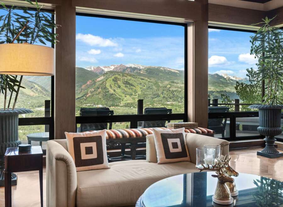 Experience breathtaking mountain views from this luxurious living space, featuring expansive windows that frame a stunning landscape.