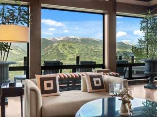 Experience breathtaking mountain views from this luxurious living space, featuring expansive windows that frame a stunning landscape.