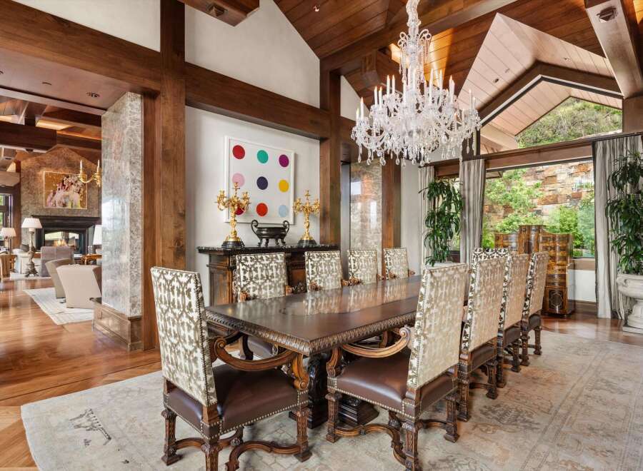Experience elegant dining in this luxurious home, featuring a grand dining room with a large wooden table and ornate chairs.