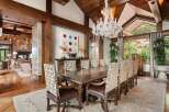 Experience elegant dining in this luxurious home, featuring a grand dining room with a large wooden table and ornate chairs.