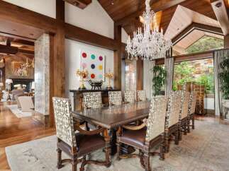 Experience elegant dining in this luxurious home, featuring a grand dining room with a large wooden table and ornate chairs.