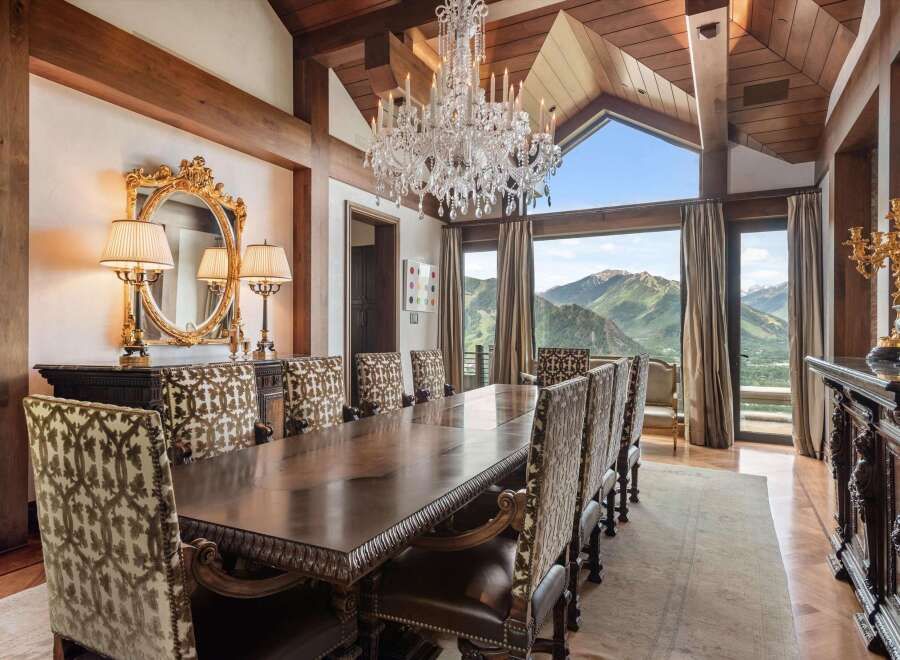Experience luxurious dining with this stunning formal dining room, featuring a grand crystal chandelier and a large, ornate wooden table perfect for hosting.
