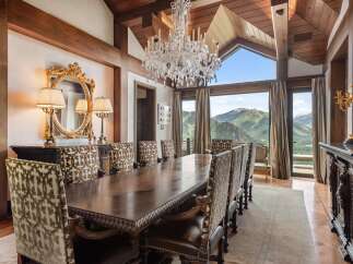 Experience luxurious dining with this stunning formal dining room, featuring a grand crystal chandelier and a large, ornate wooden table perfect for hosting.