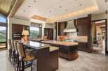 Experience luxury living in this stunning gourmet kitchen, featuring custom dark wood cabinetry, granite countertops, and a large island perfect for entertaining.