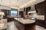Experience luxury in this expansive kitchen featuring rich, dark wood cabinetry and gleaming granite countertops.