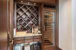Indulge in the ultimate entertaining experience with this custom-built wine cellar, featuring a diamond-patterned wine rack and a state-of-the-art wine refrigerator.