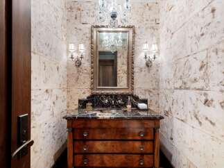 Experience luxury in this powder room featuring a stunning marble vanity with a dark wood cabinet base.