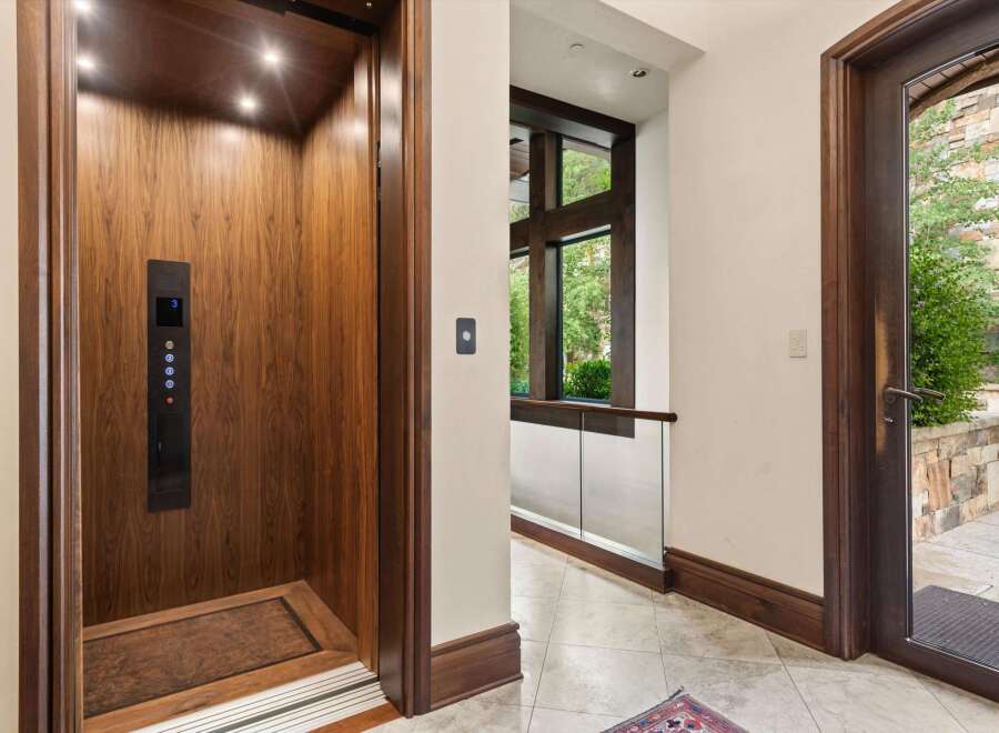 Experience seamless living with this elegant elevator, featuring rich wood paneling and modern controls.