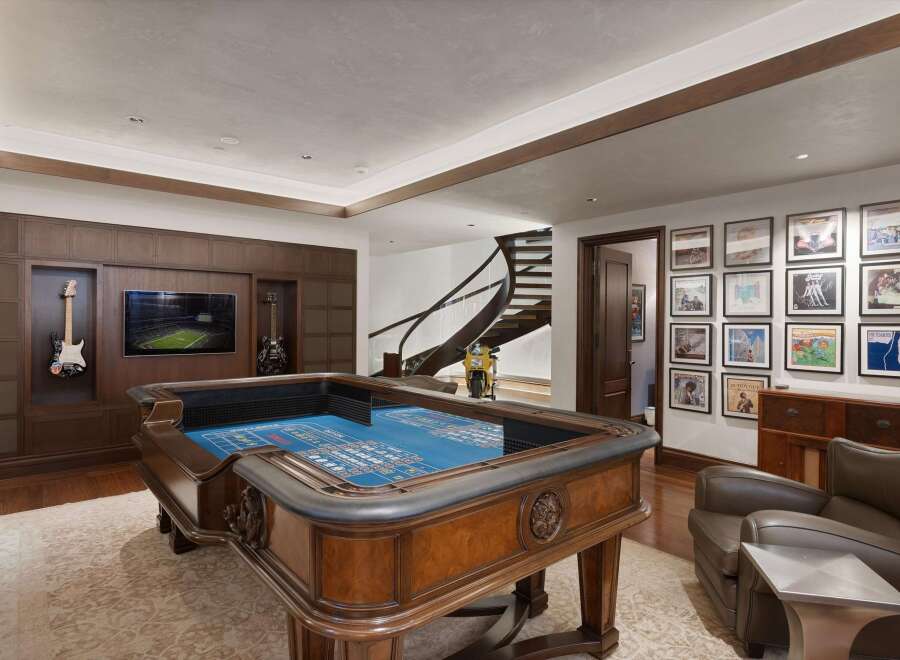 Experience ultimate entertainment in this luxurious game room, featuring a professional-grade craps table and a large screen TV perfect for game day.