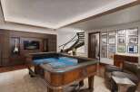 Experience ultimate entertainment in this luxurious game room, featuring a professional-grade craps table and a large screen TV perfect for game day.