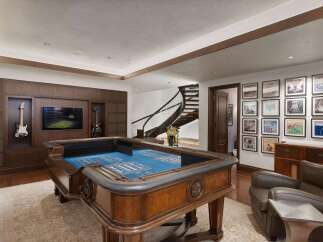 Experience ultimate entertainment in this luxurious game room, featuring a professional-grade craps table and a large screen TV perfect for game day.