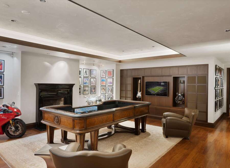Experience ultimate entertainment in this luxurious game room, featuring a custom roulette table and a large flat-screen TV.