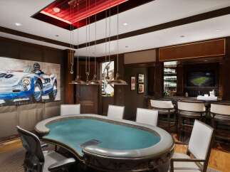Experience ultimate entertainment in this luxurious game room, featuring a professional poker table and a fully equipped bar.
