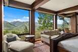 Experience breathtaking mountain views from this luxurious bedroom, featuring expansive windows that frame a stunning landscape.