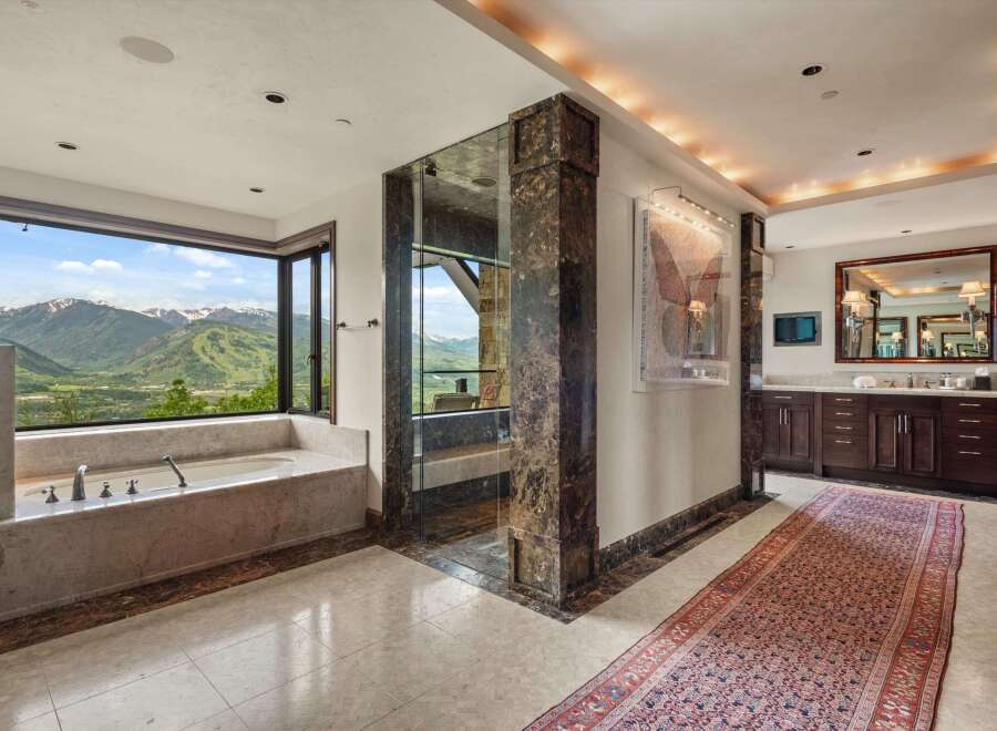 Experience unparalleled luxury in this stunning bathroom, featuring a deep soaking tub with breathtaking mountain views.