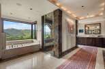 Experience unparalleled luxury in this stunning bathroom, featuring a deep soaking tub with breathtaking mountain views.