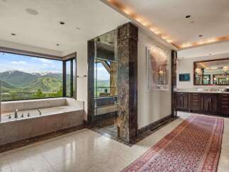 Experience unparalleled luxury in this stunning bathroom, featuring a deep soaking tub with breathtaking mountain views.