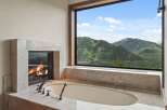 Indulge in ultimate relaxation with this luxurious bathroom featuring a stunning marble fireplace and a deep soaking tub.