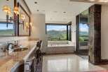 Indulge in luxury with this stunning bathroom featuring a spacious soaking tub with breathtaking mountain views.