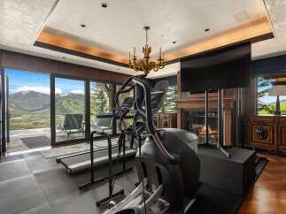 Experience luxury fitness with this state-of-the-art home gym, featuring a treadmill and elliptical with breathtaking mountain views.