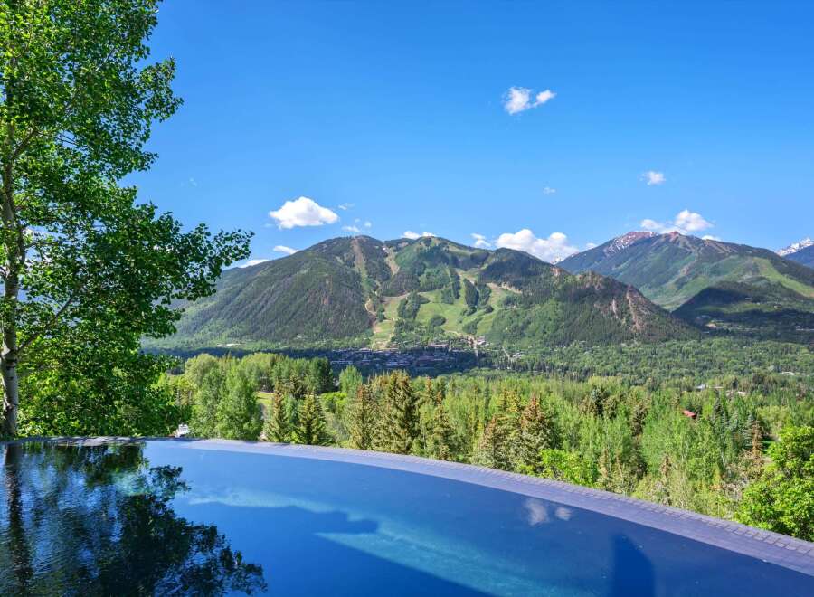 Experience luxury living with this stunning infinity pool offering breathtaking panoramic views of the surrounding mountains and lush greenery.