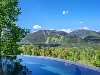 Experience luxury living with this stunning infinity pool offering breathtaking panoramic views of the surrounding mountains and lush greenery.
