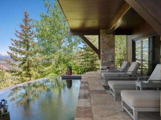 Experience luxury outdoor living with this stunning infinity pool overlooking a picturesque mountain landscape.