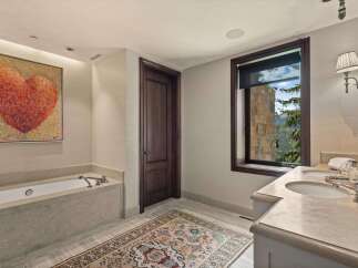 Indulge in luxury with this stunning bathroom featuring a deep soaking tub and a spacious double vanity.