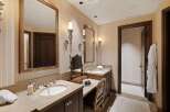Experience luxury in this elegant bathroom featuring dual vanities with marble countertops and undermount sinks.