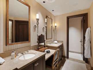 Experience luxury in this elegant bathroom featuring dual vanities with marble countertops and undermount sinks.