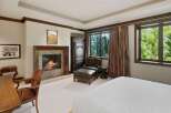 Experience ultimate comfort in this luxurious bedroom, featuring a cozy fireplace perfect for chilly evenings.
