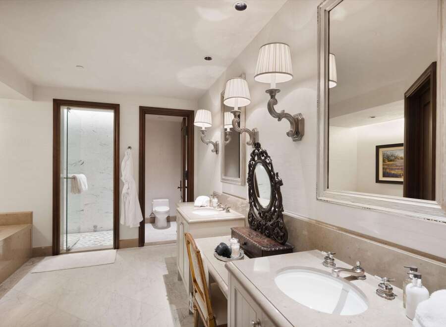 Indulge in luxury with this exquisite bathroom featuring dual vanities, a spacious walk-in shower, and a separate water closet.
