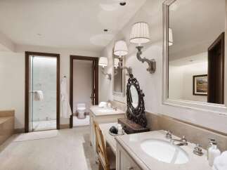 Indulge in luxury with this exquisite bathroom featuring dual vanities, a spacious walk-in shower, and a separate water closet.