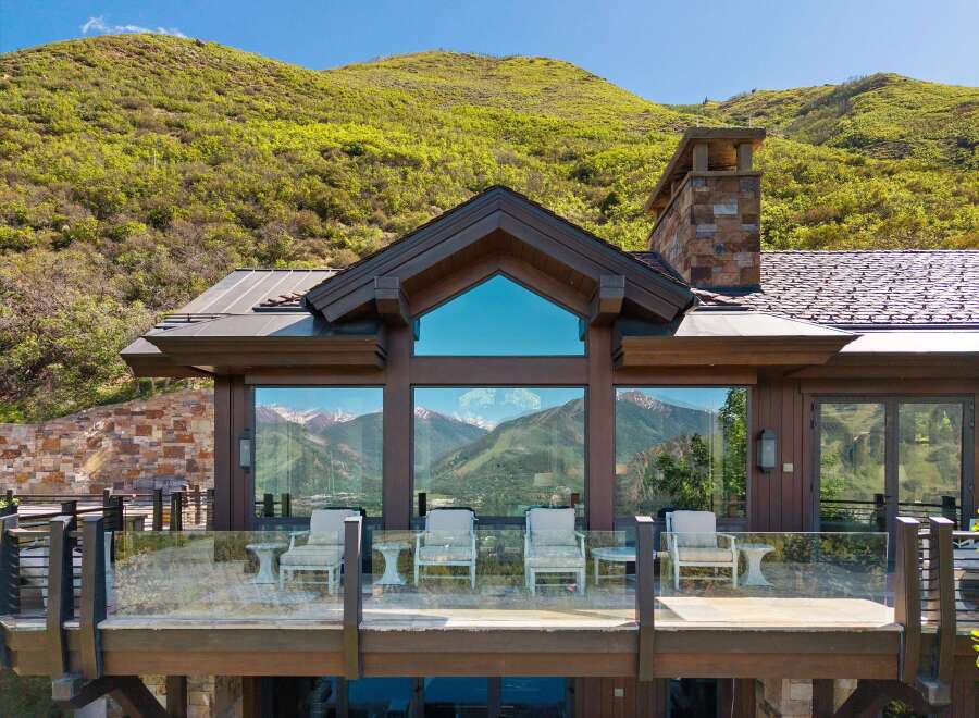 Experience breathtaking mountain views from this stunning modern home, featuring expansive windows and a spacious deck perfect for enjoying the scenery.