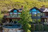 Experience luxury mountain living in this stunning estate, featuring expansive floor-to-ceiling windows that capture breathtaking panoramic views of snow-capped peaks and lush green hillsides.