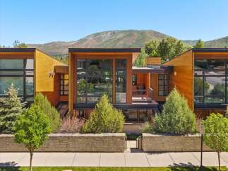 Experience modern luxury in this stunning architectural home, featuring expansive glass windows and warm wood accents that seamlessly blend indoor and outdoor living.