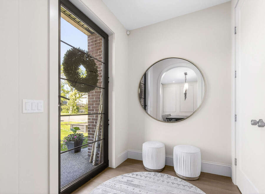 Step into this inviting entryway featuring a large glass door with a decorative wreath, offering a glimpse of the outdoors.