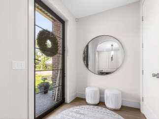 Step into this inviting entryway featuring a large glass door with a decorative wreath, offering a glimpse of the outdoors.