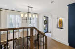 Experience elegant dining in this spacious room, featuring a large wooden table perfect for gatherings and illuminated by a stylish modern chandelier.