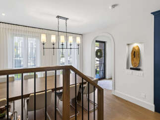 Experience elegant dining in this spacious room, featuring a large wooden table perfect for gatherings and illuminated by a stylish modern chandelier.