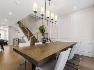 Experience elegant dining in this spacious home, featuring a large wooden dining table perfect for gatherings.