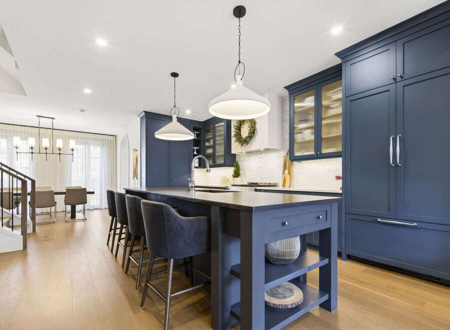 Experience luxury in this stunning modern kitchen, featuring deep navy custom cabinetry and a spacious island perfect for entertaining.