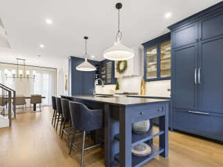 Experience luxury in this stunning modern kitchen, featuring deep navy custom cabinetry and a spacious island perfect for entertaining.