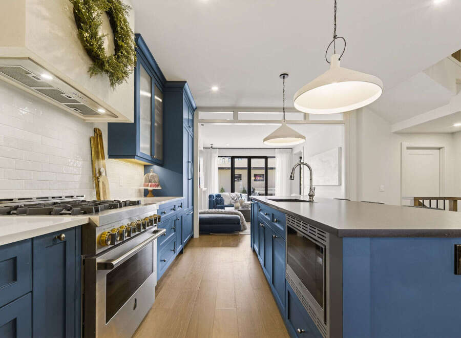 Experience luxury in this stunning kitchen featuring deep blue cabinetry and a sleek white subway tile backsplash.