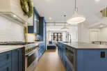 Experience luxury in this stunning kitchen featuring deep blue cabinetry and a sleek white subway tile backsplash.
