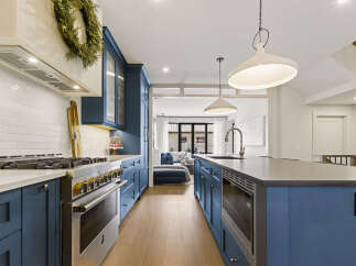 Experience luxury in this stunning kitchen featuring deep blue cabinetry and a sleek white subway tile backsplash.