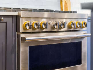 Experience culinary excellence with this professional-grade gas range, featuring a sleek stainless steel finish and striking yellow control knobs.